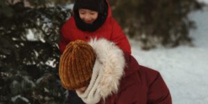 two children playing with snow near tree