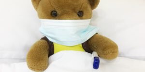 brown bear plush toy on white textile